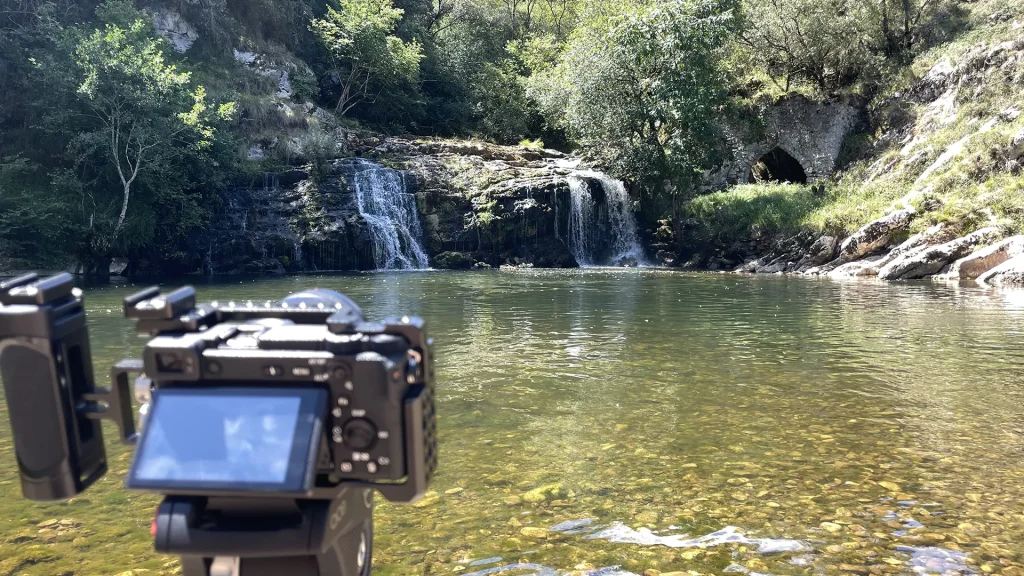 Realizador con cámara dslr trabajando en exteriores, equipo de trípode, objetivos e iluminación LED